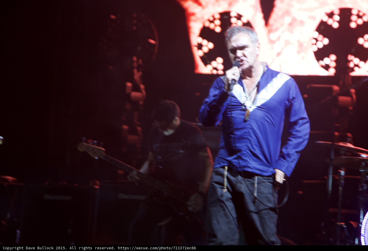 Morrissey Singing Close Up Blue Shirt Hand On Hip Bassist Silhouette Red Video Screen Lights