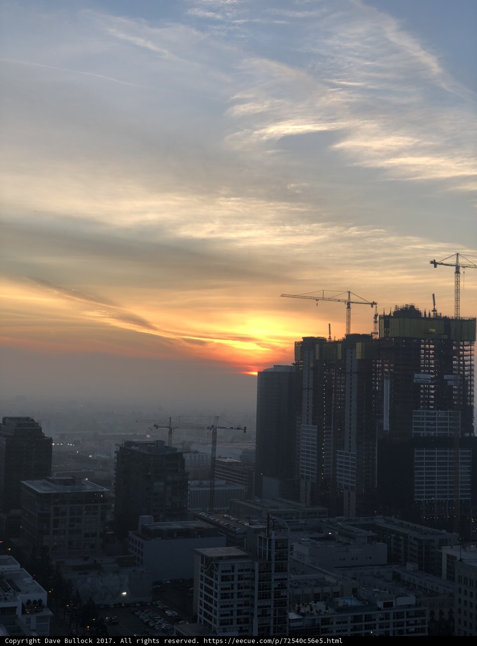 Sunset over the City Skyline with Construction Cranes