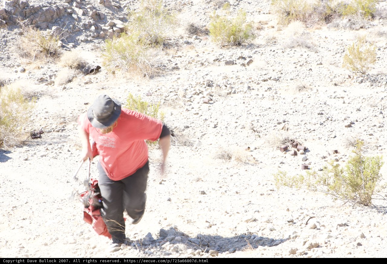 Red Shirted Man Walks Down Gravel Road