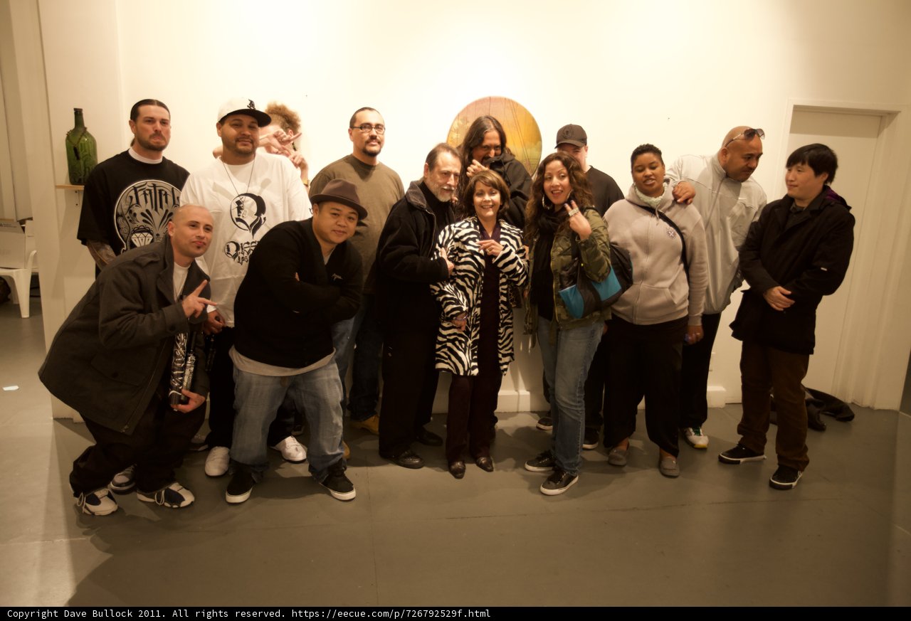 Group of 14 friends pose for a photo in art gallery