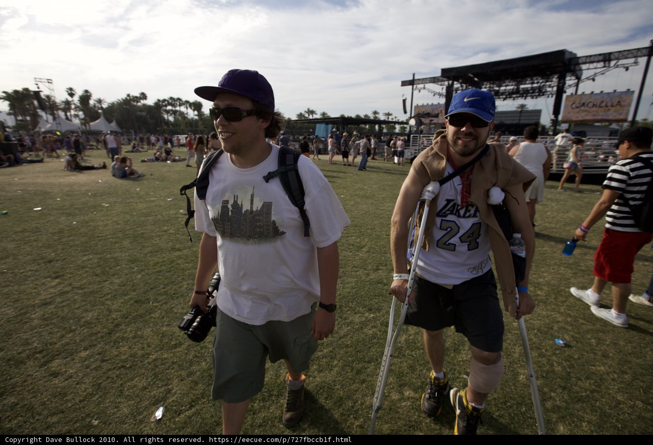 Overcoming Obstacles Caption: Two men in baseball hats walk on crutches through the lively Coachella crowd.