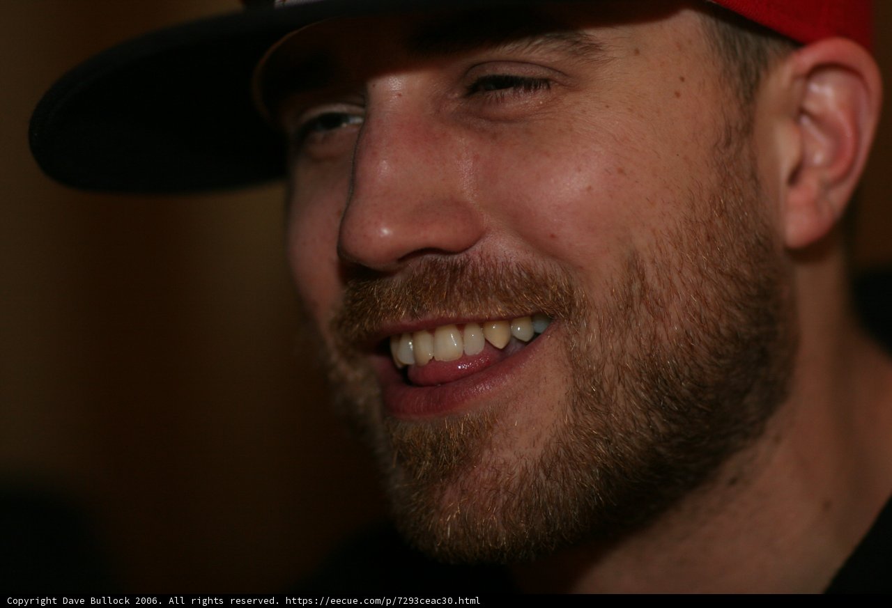 Smiling Bearded Man in Red Hat