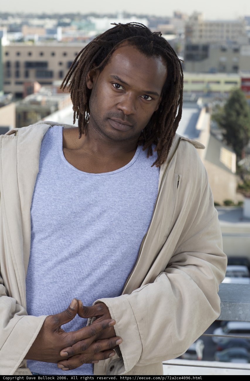 Dreadlocked Man Poses with Car