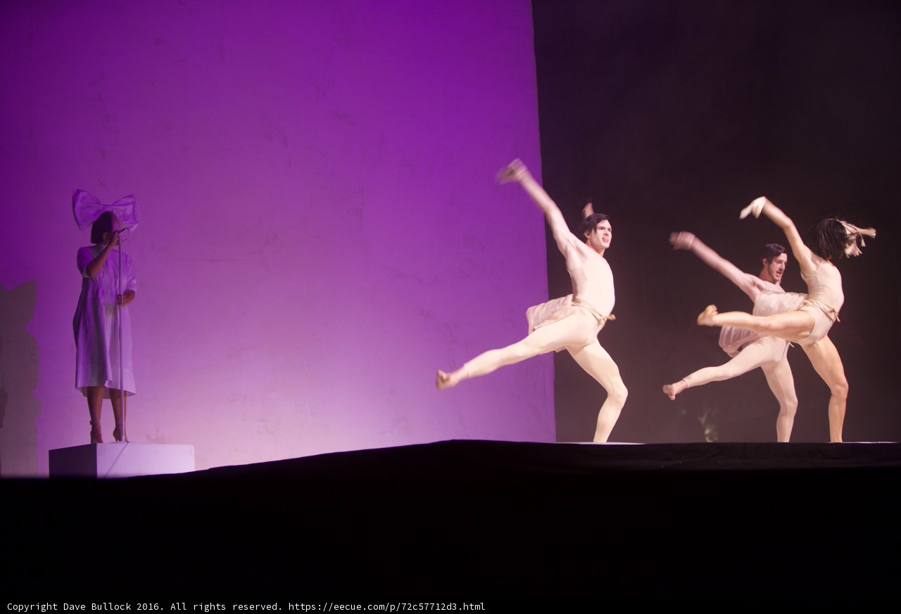 Three Dancers Take the Stage in a Regal Purple Light
