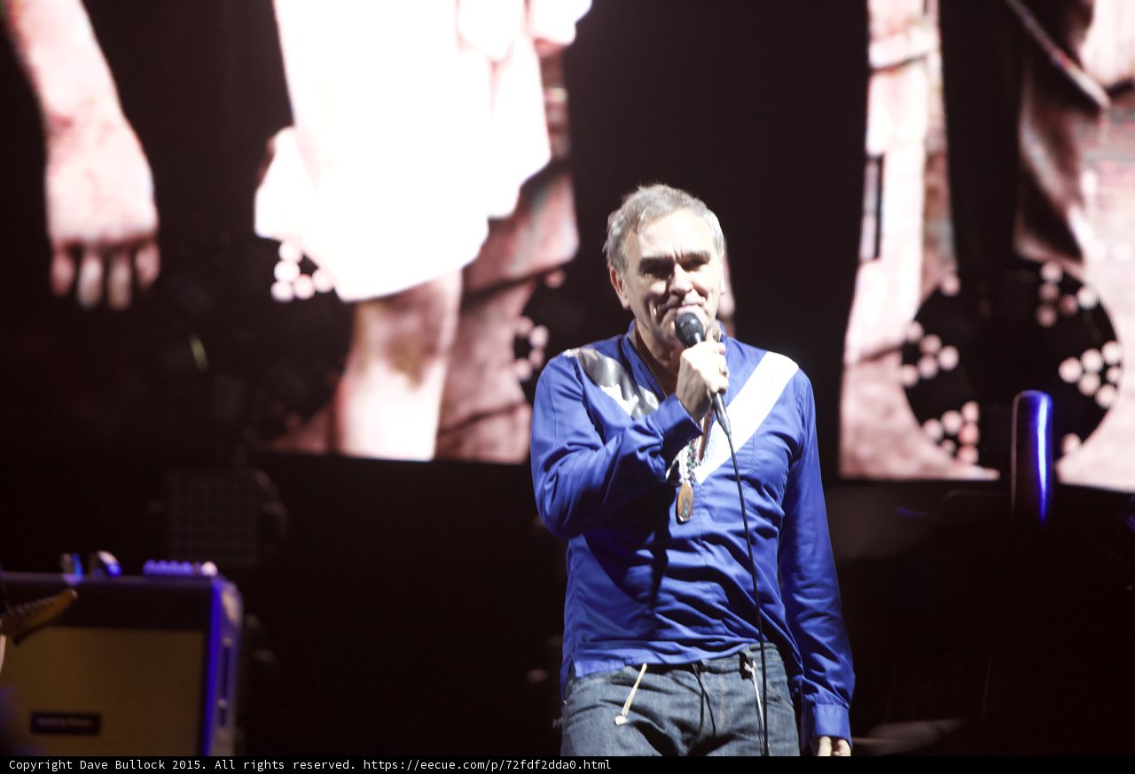 Morrissey Three Quarter Portrait Smiling Blue Shirt Smiths Dangling Hands Video Screen Yellow Amp