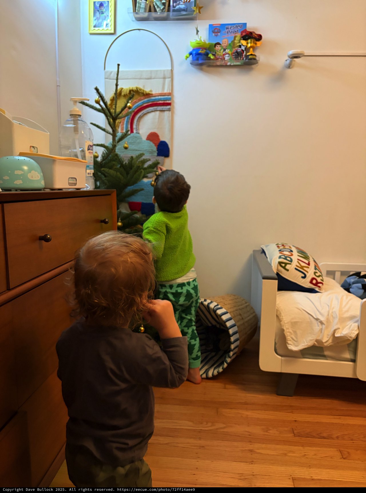 Children Decorating Small Christmas Tree in Bedroom