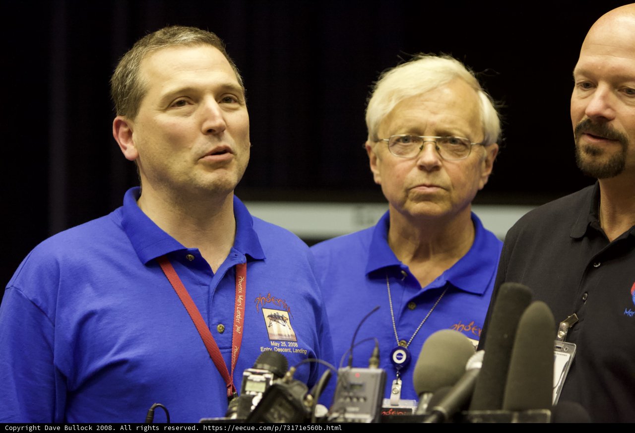 Three Men in Blue Shirts Answer Press Questions