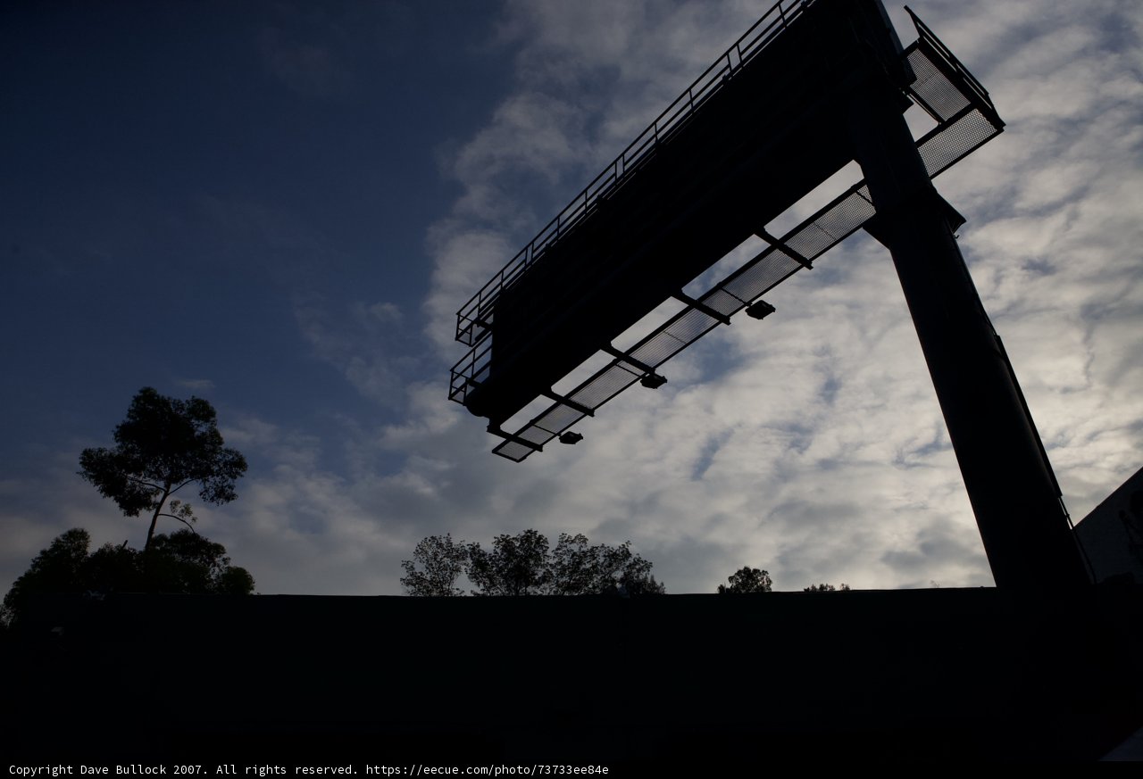 A Billboard's Silhouette Under a Cloudy Sky
