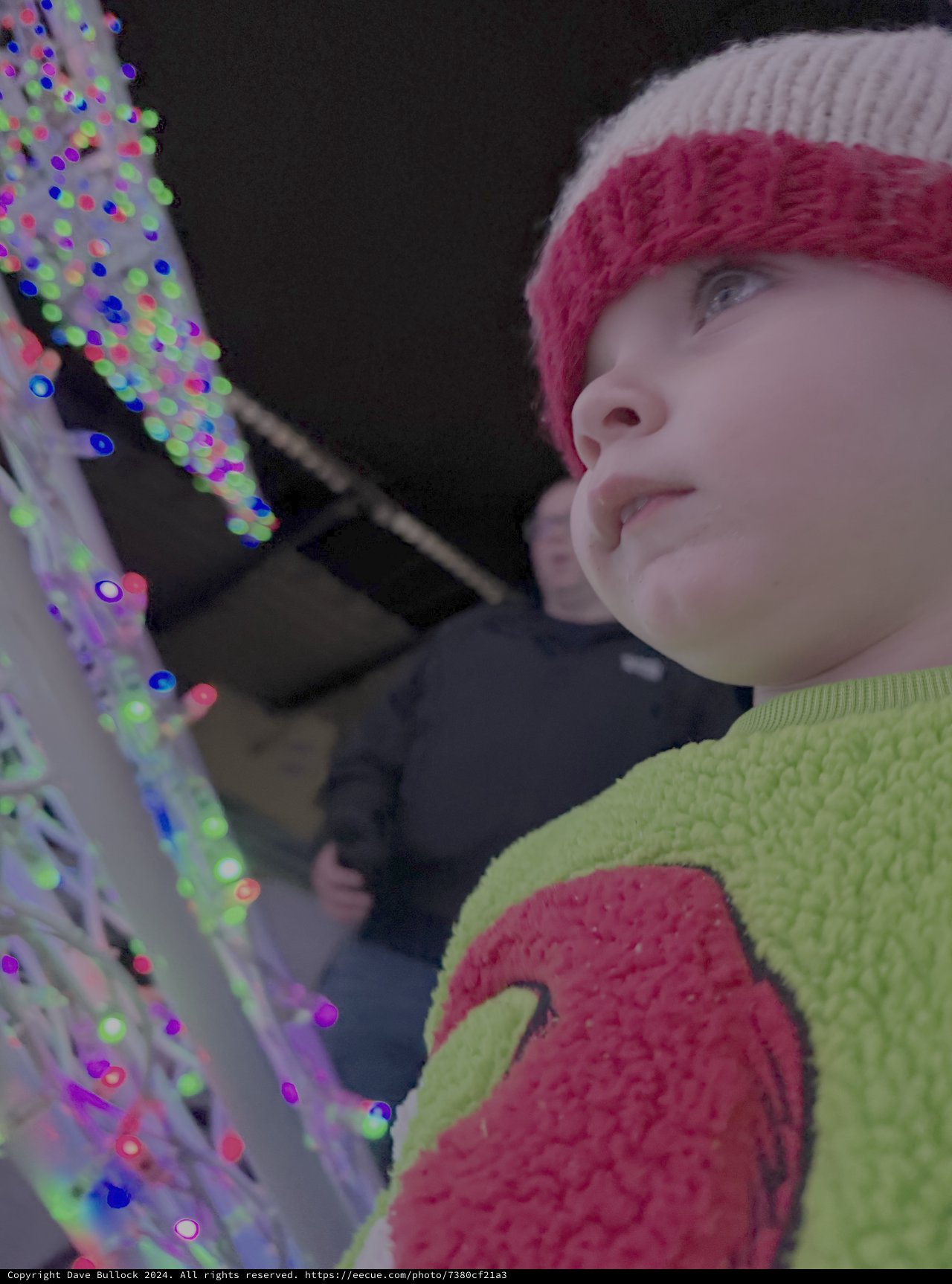Child Mesmerized by Colorful Light Display