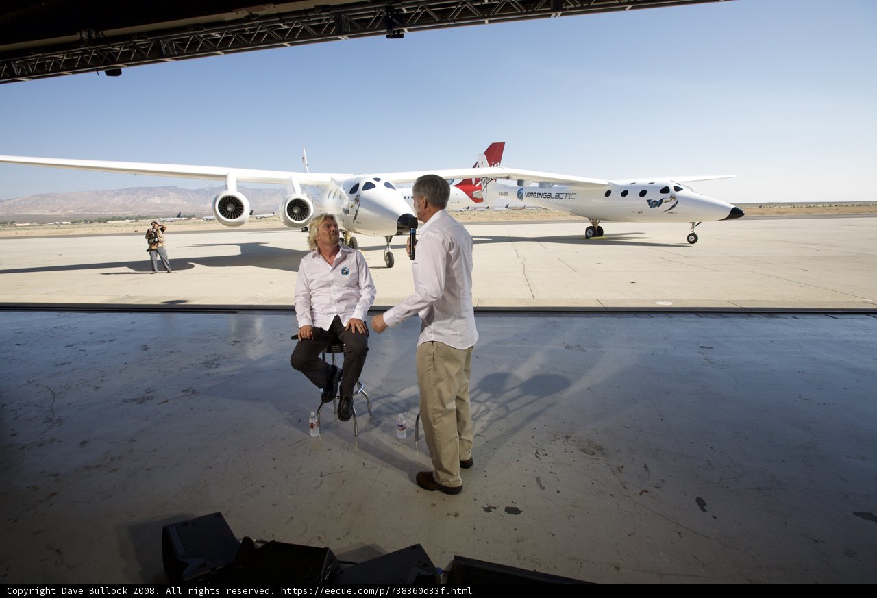 Richard Branson and Friend Relaxing Near White Knight Two Plane at Airport