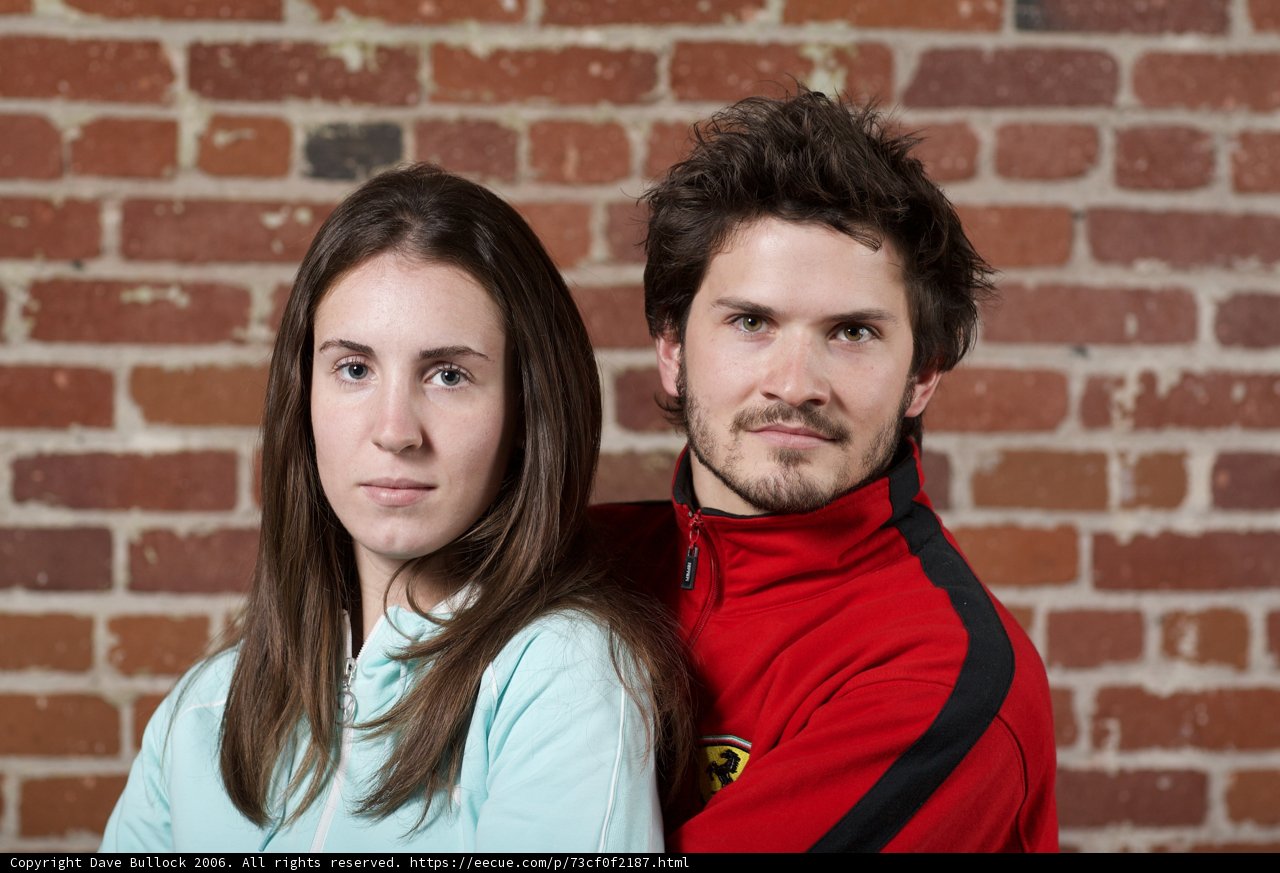 Couple Poses in Front of Brick Wall