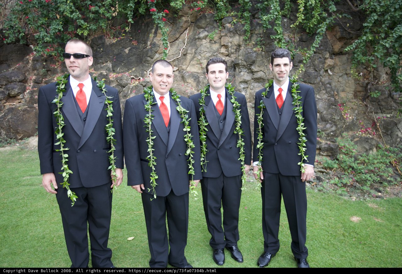 Four Men in Suits Posed by a Rock Wall
