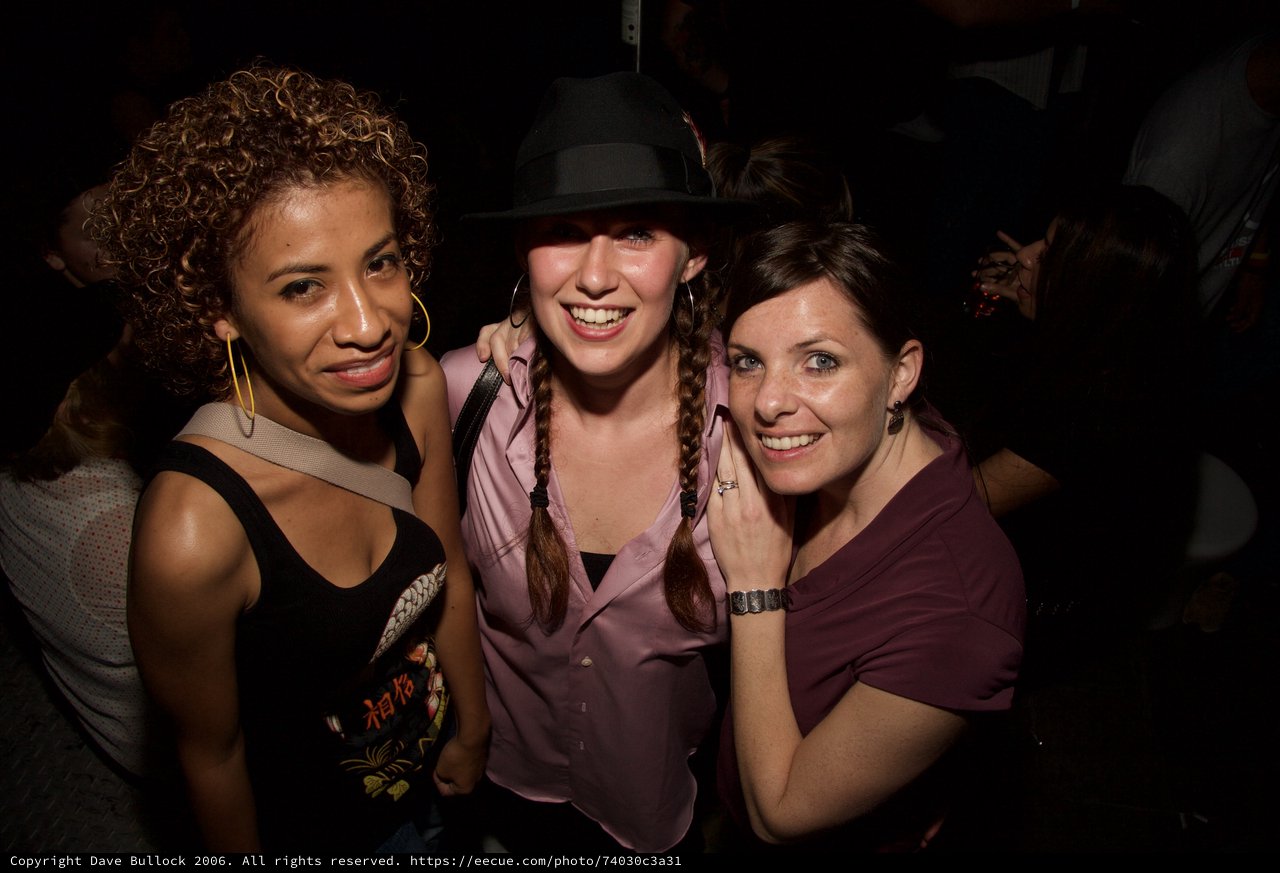 Three Friends Smiling at a Nightclub Party