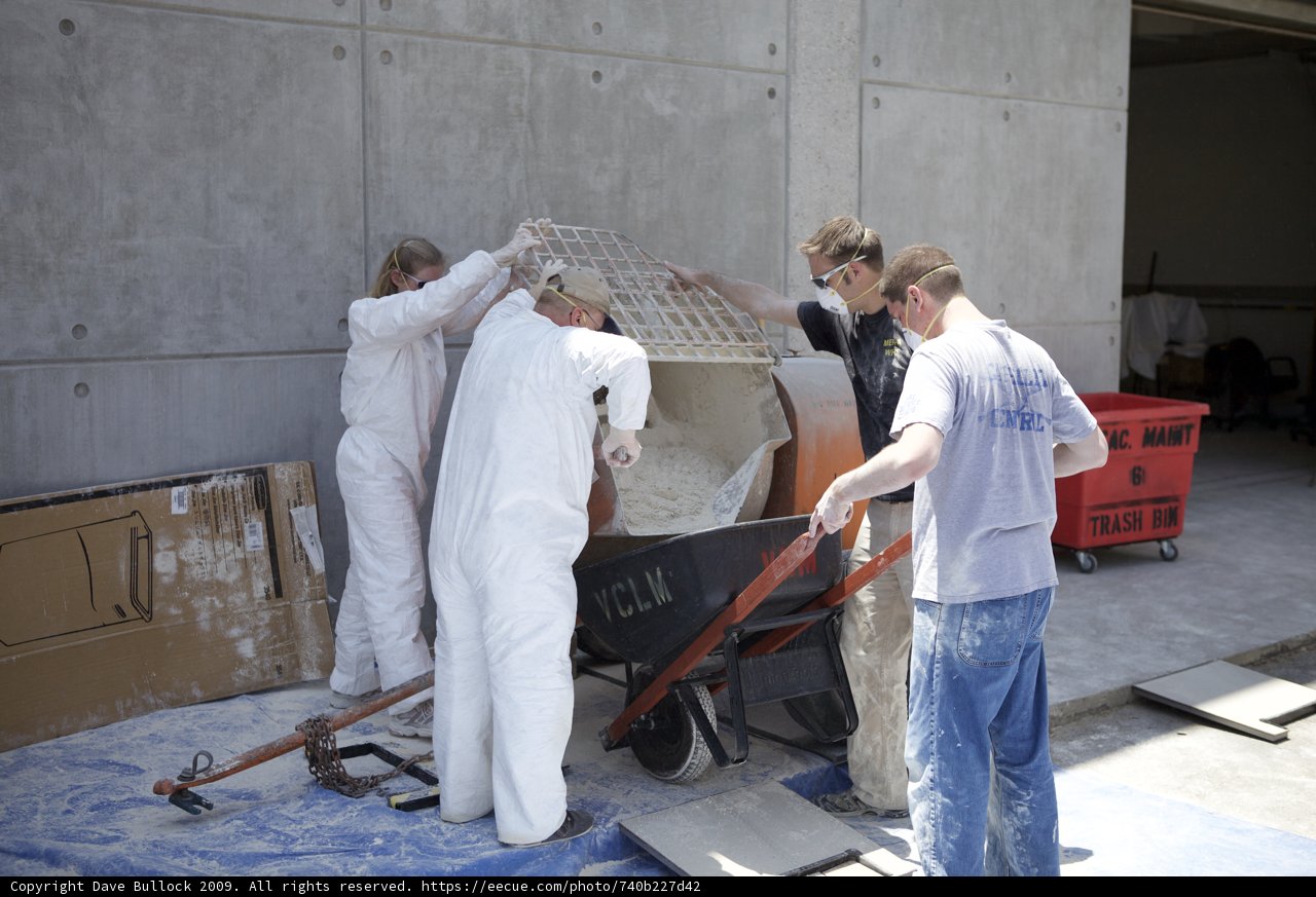Four men working on a wooden form for a concrete wall