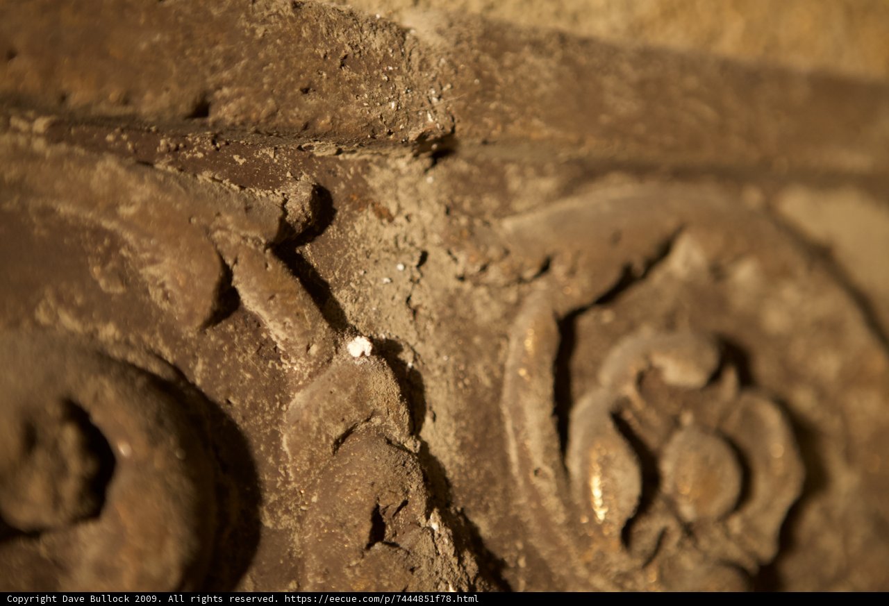 Intricate Carvings on Rusty Stone Wall