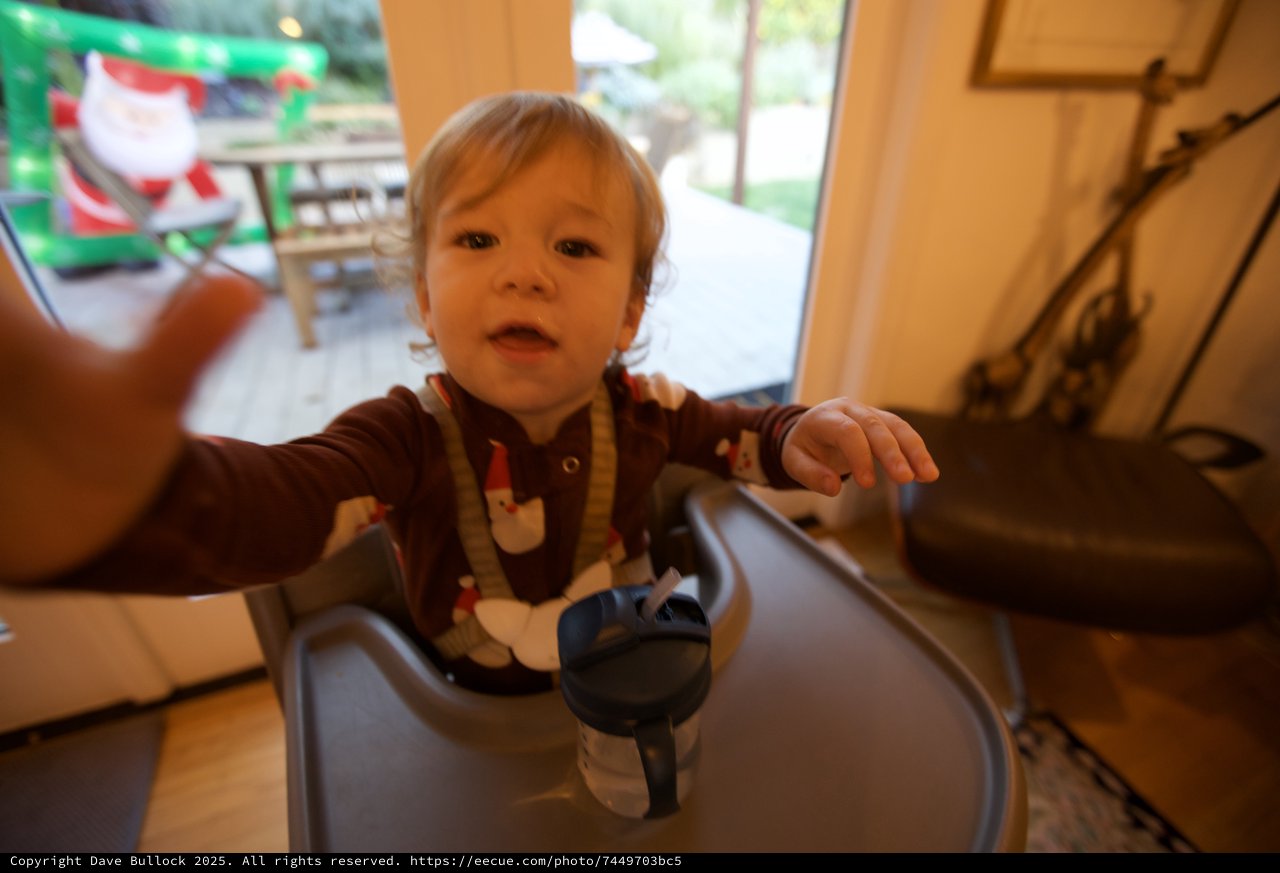 Toddler in Festive Pajamas Reaching Toward Camera