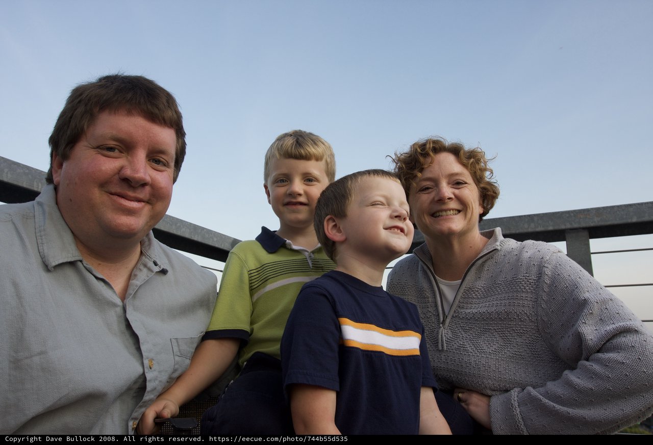 Family of Four Smiling Together on Outdoor Deck