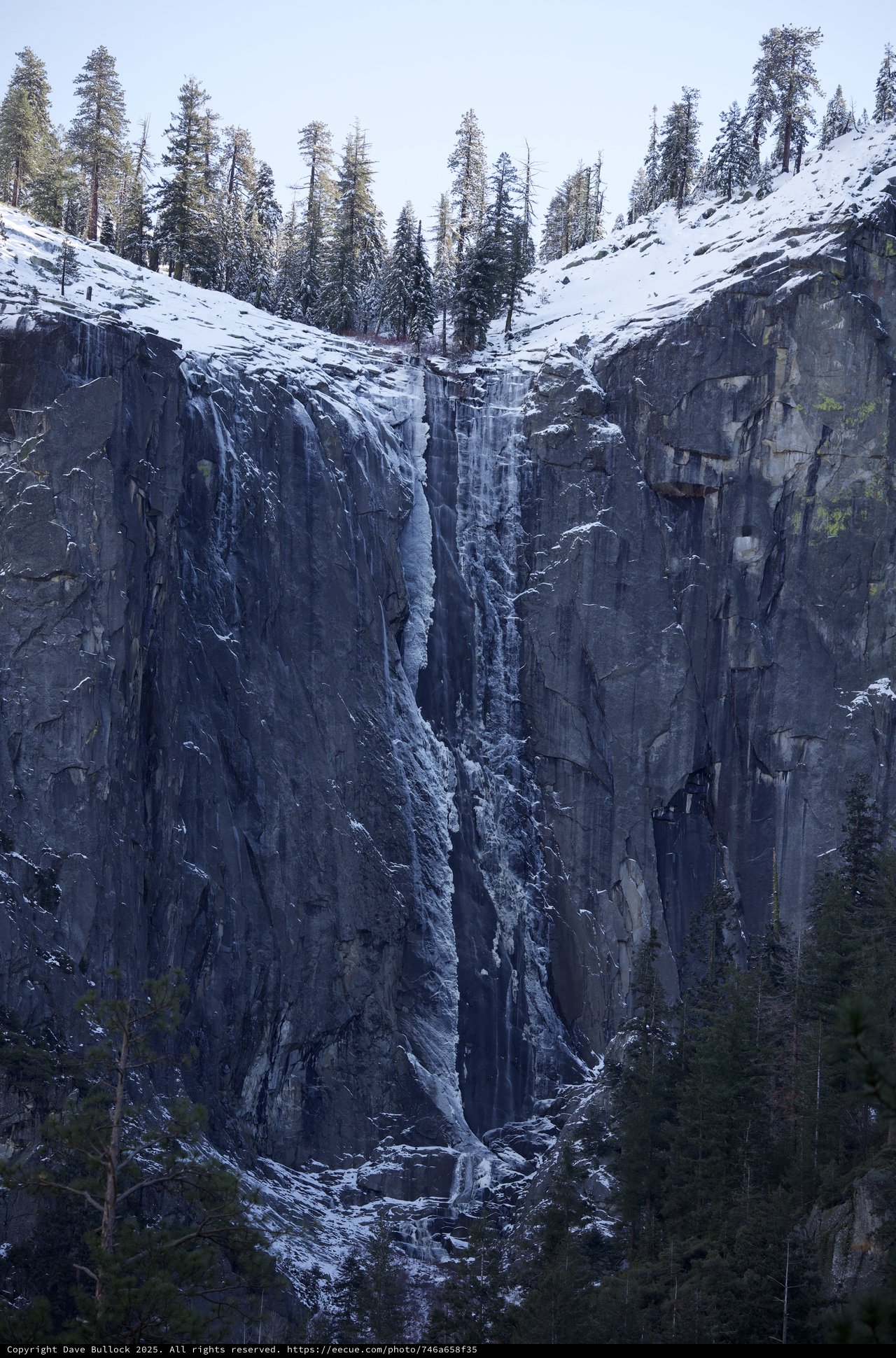 Frozen Waterfall Cascading Through Snow-Covered Granite Cliffs