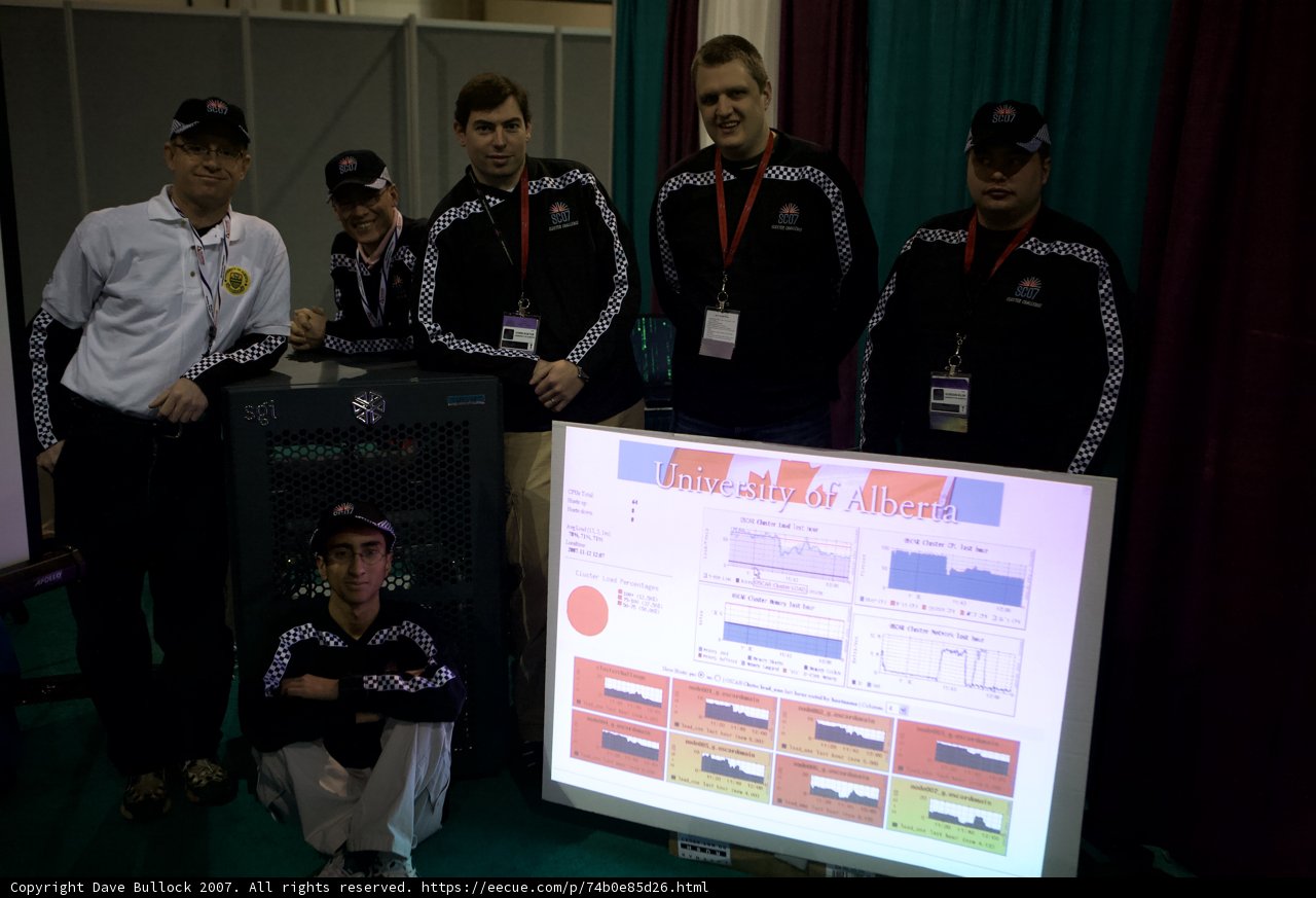 Group of Men Gathered Around Large Screen at Super Computing 07 Conference