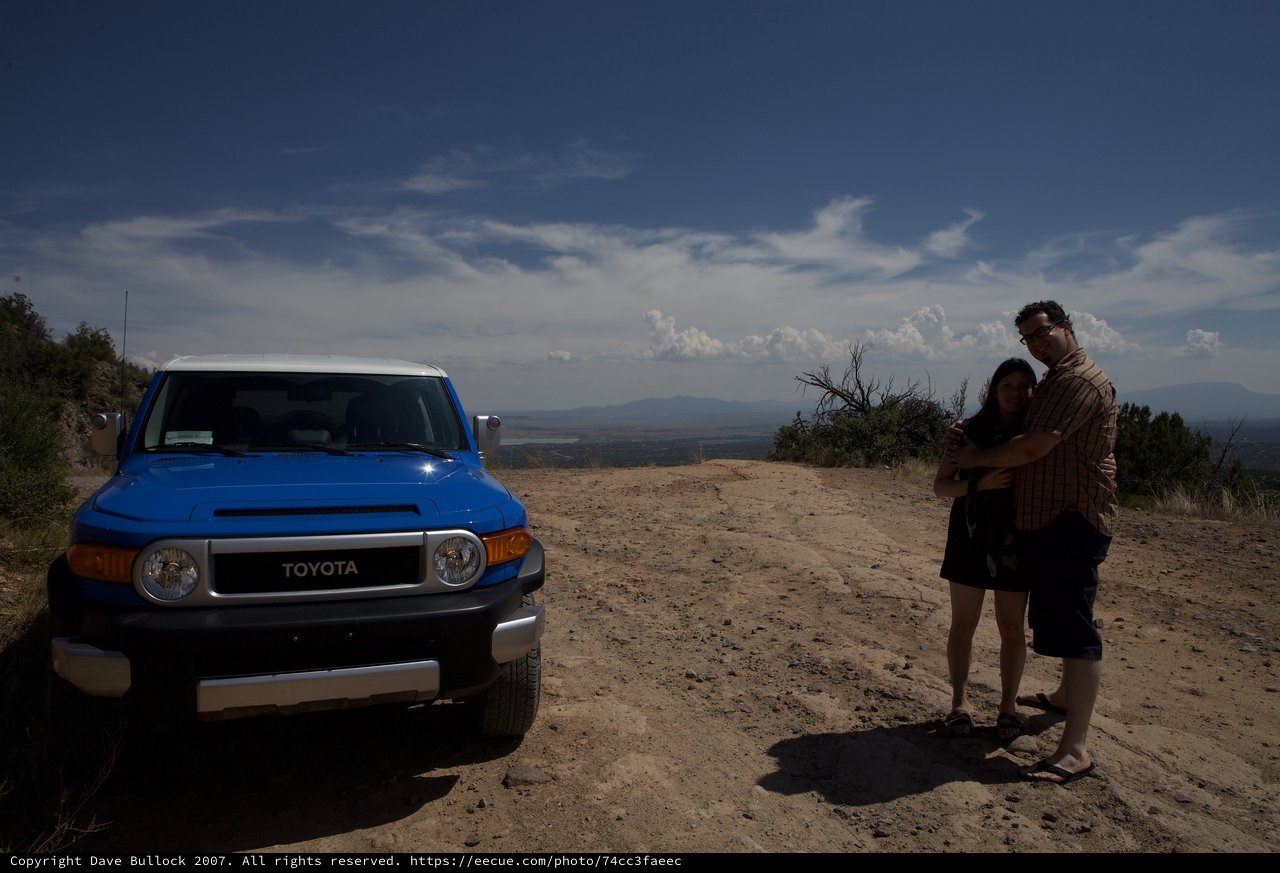 Couple Embracing Beside Toyota FJ Cruiser on Mountain Trail