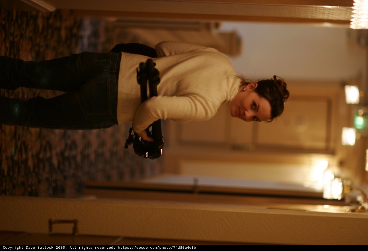 Woman Glances Back in Warmly Lit Hotel Corridor