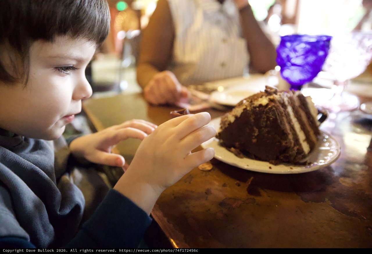 Young Boy Anticipating a Decadent Chocolate Cake