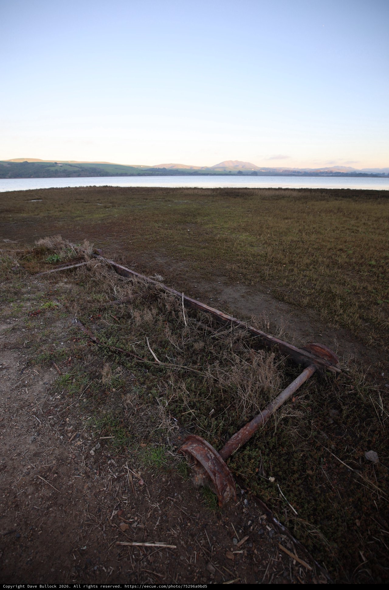 Rusted Anchor Resting on Coastal Grassland at Dusk