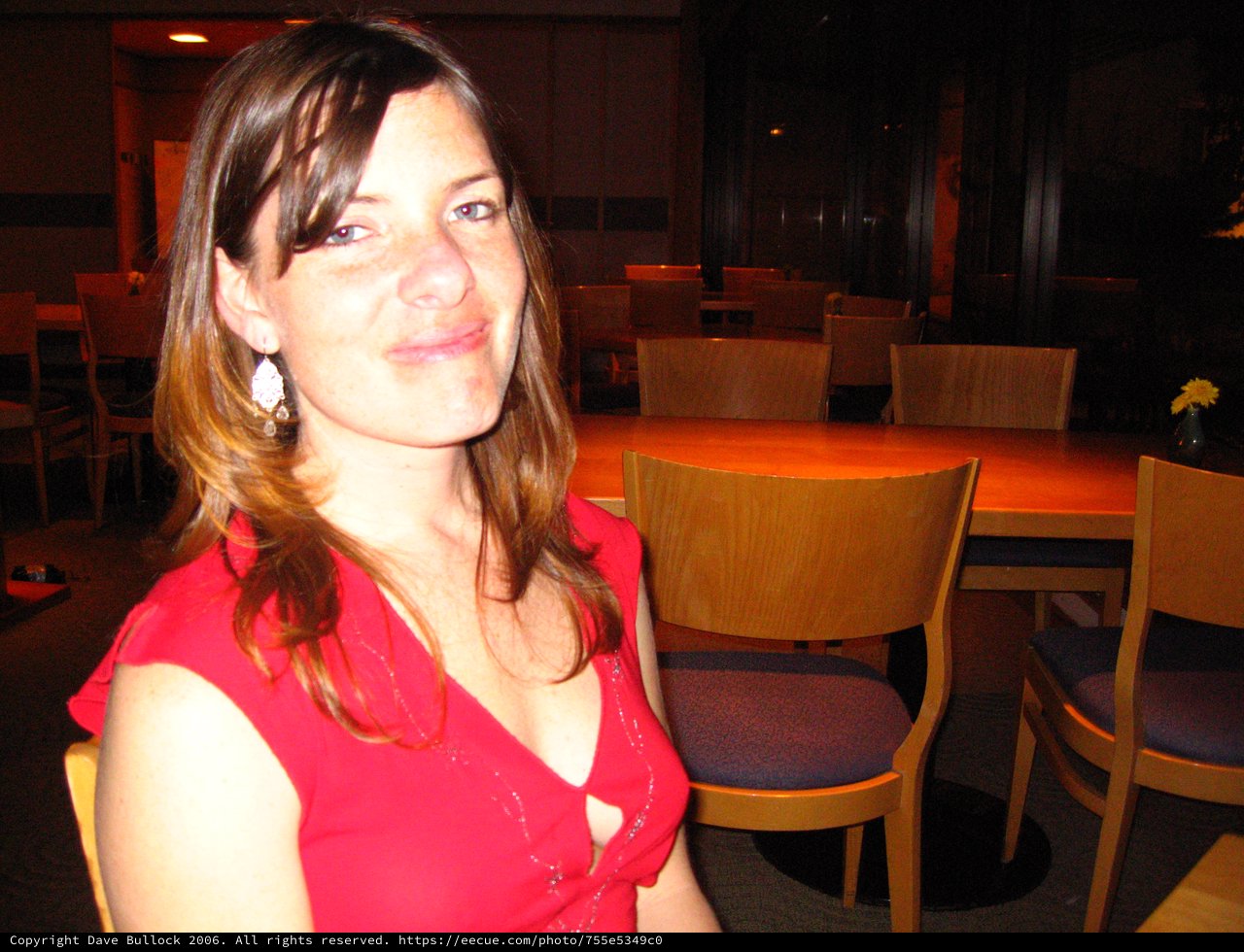 Woman in Red at Dimly Lit Restaurant Table