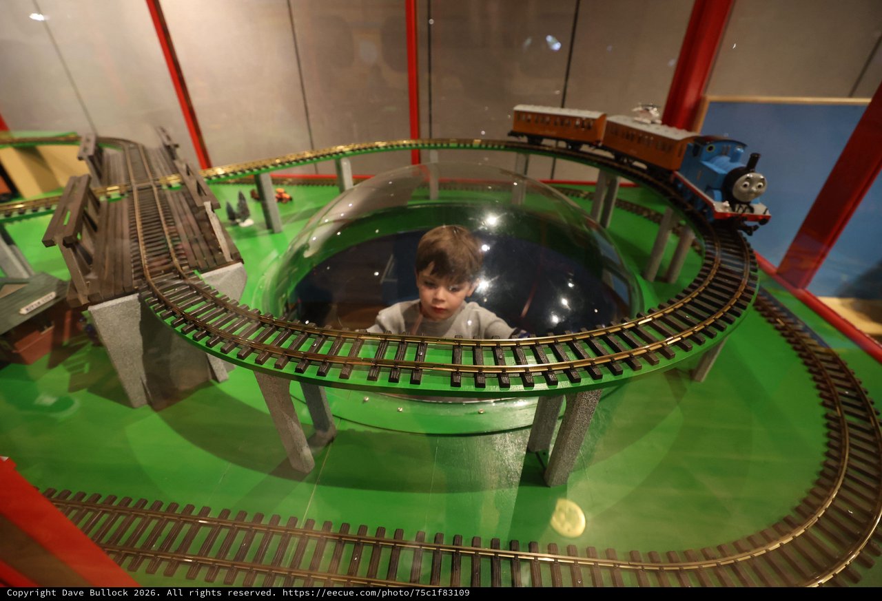 Child Observing Model Train Display in Museum Dome