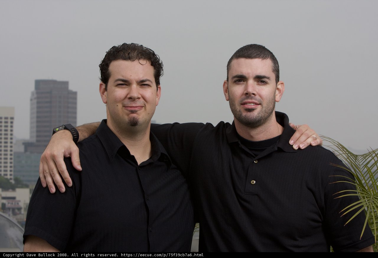Two Happy Men Posing in Front of an Urban Building