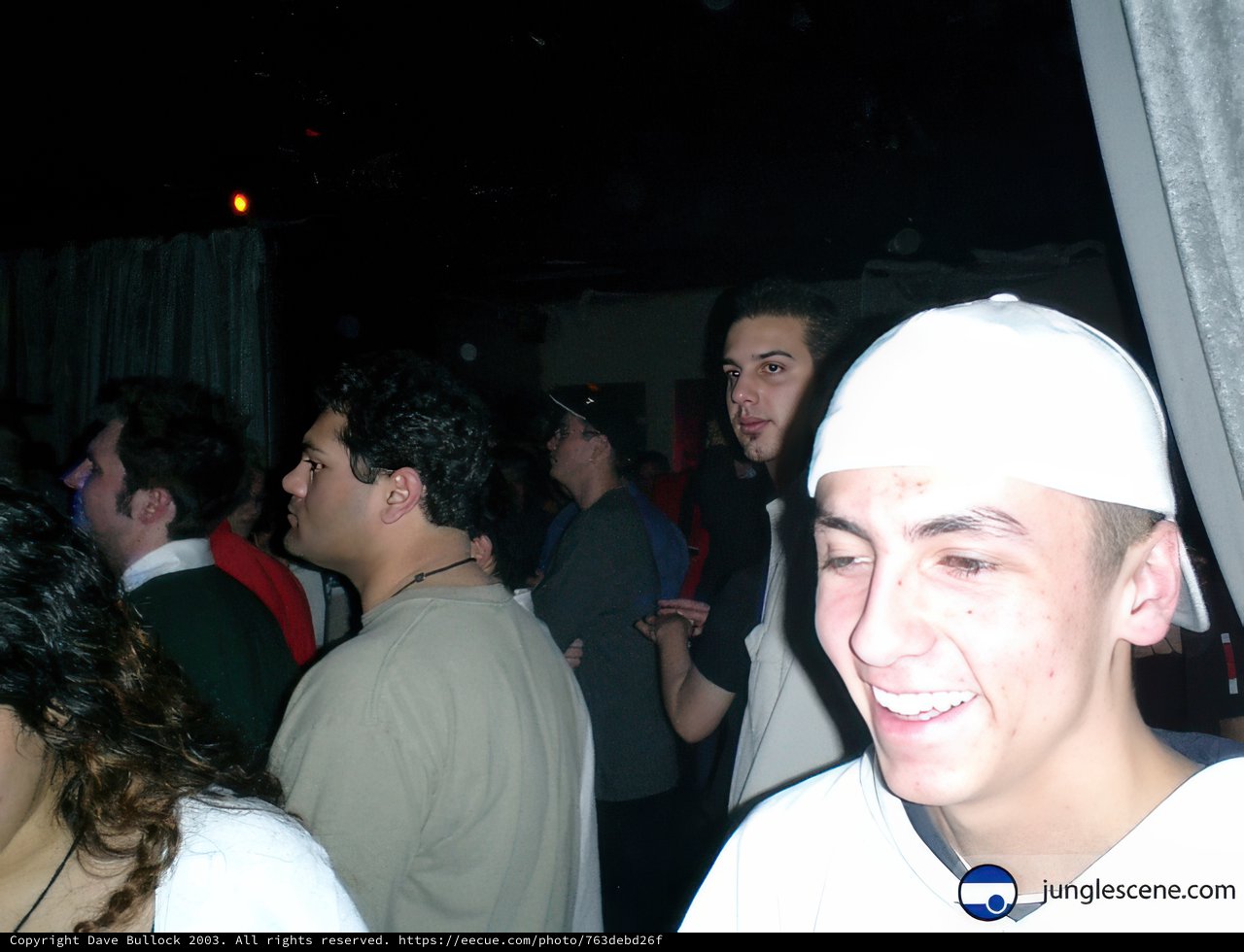 Smiling Man Stands Out in Nightclub Crowd