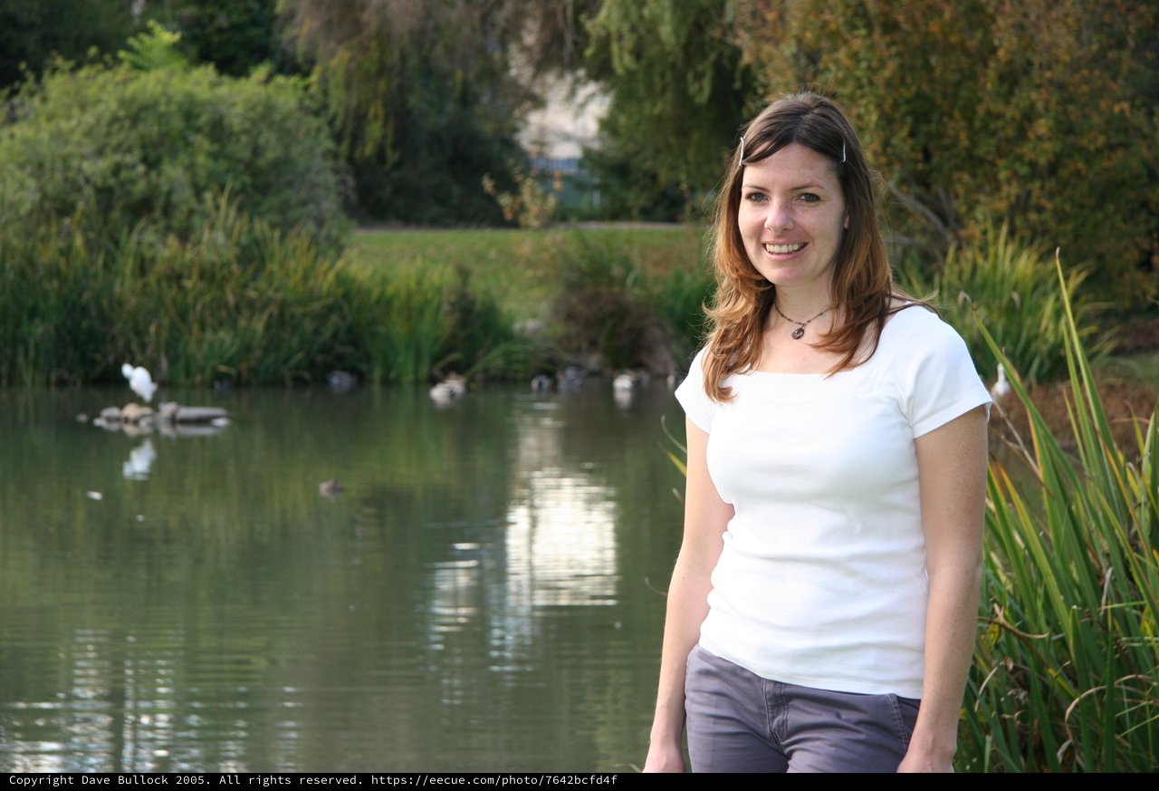 Smiling Woman by a Tranquil Park Pond