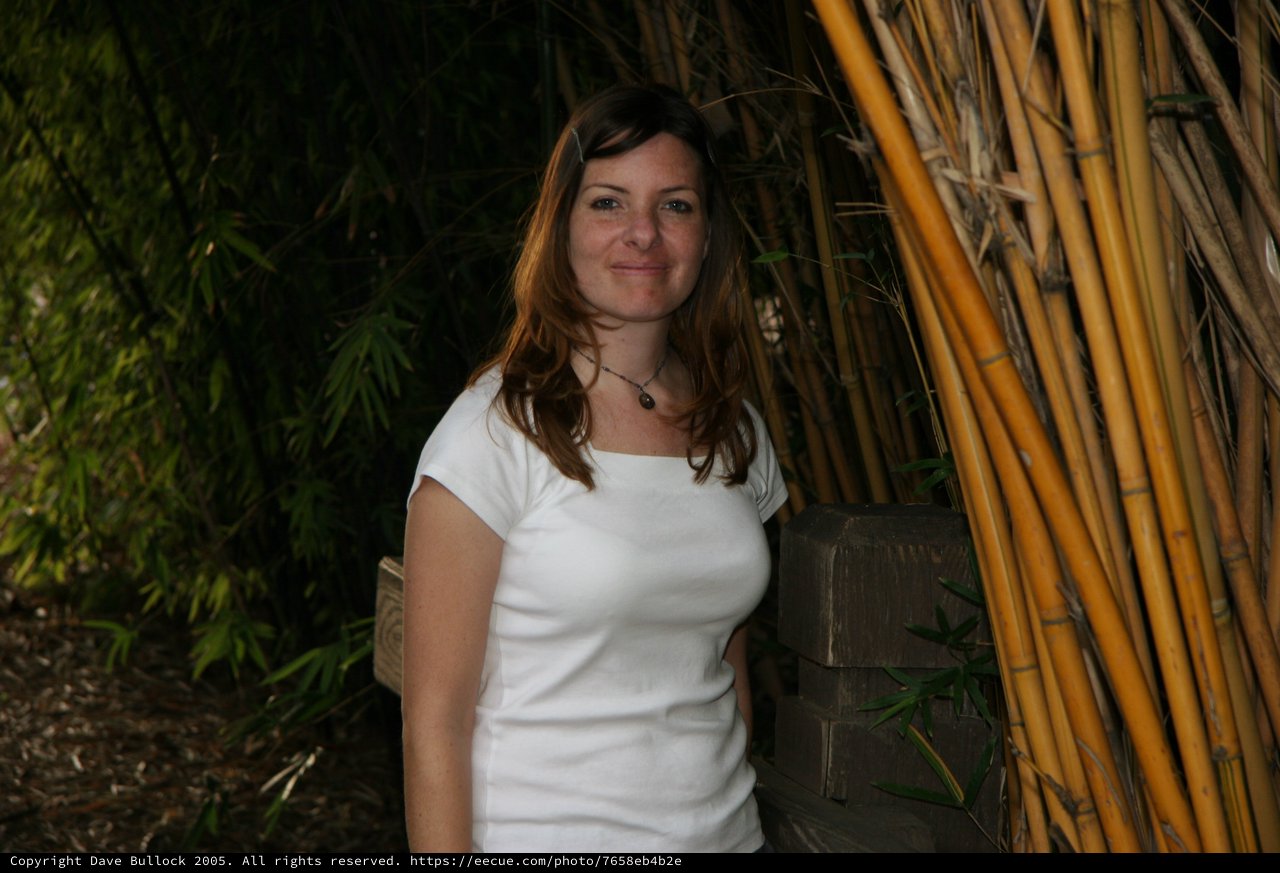 Woman Smiling Among Bamboo in Garden Setting