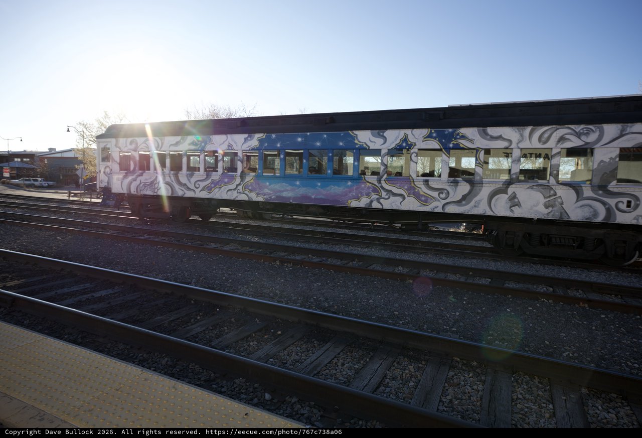 Graffiti-Covered Train Car at Sunset on Railway Tracks