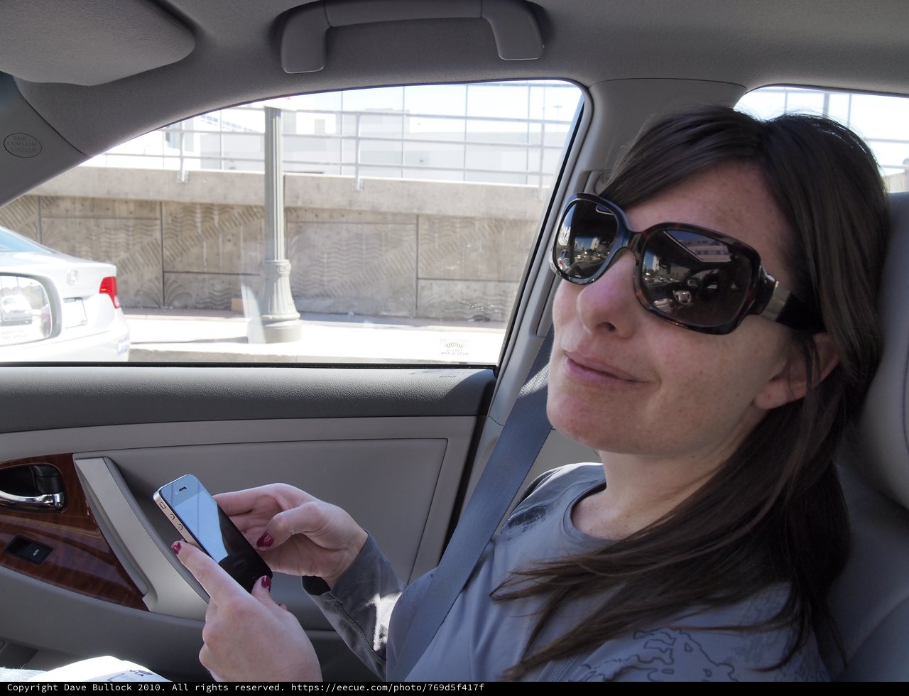 Woman Texting on Smartphone in Urban Car Ride