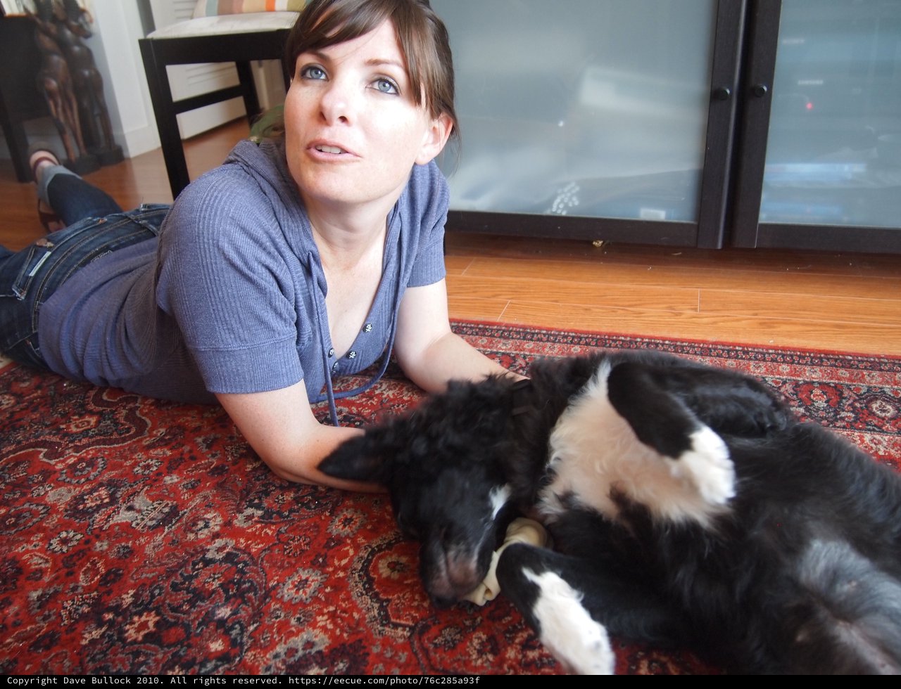 Woman Relaxing on Rug with Black and White Dog