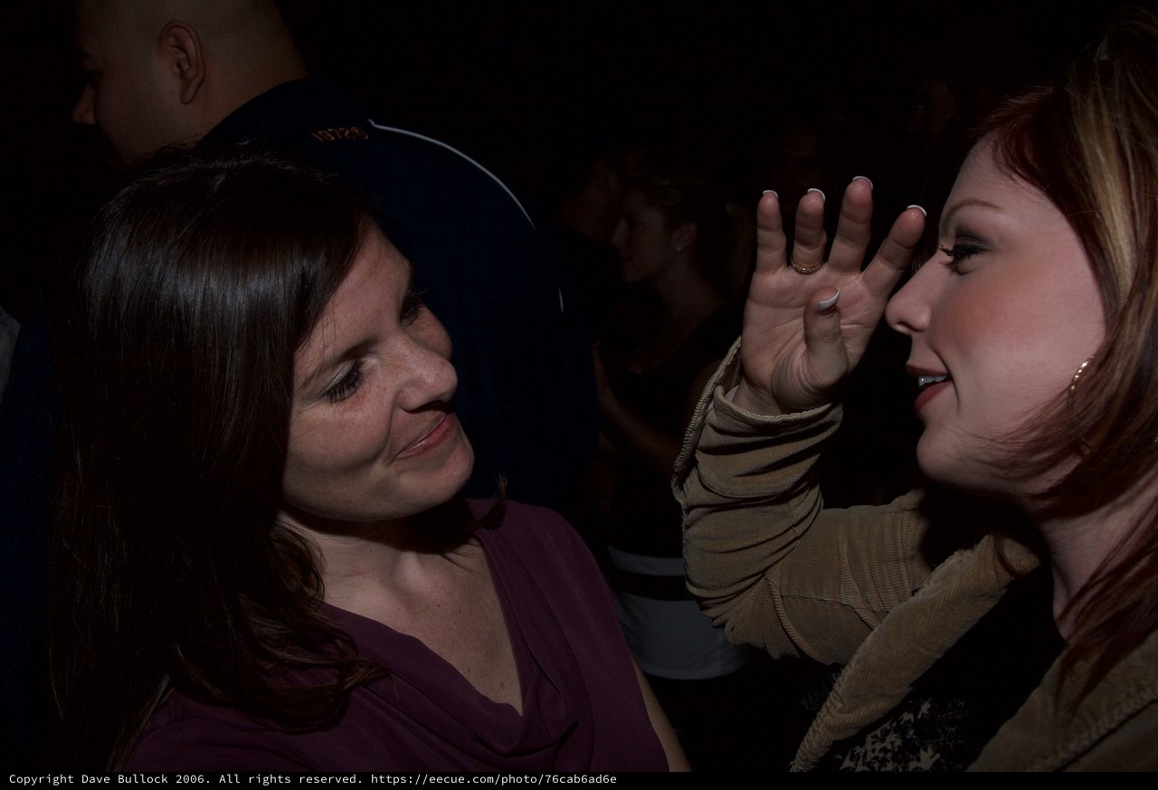 Two Women in Animated Conversation at Nighttime Event