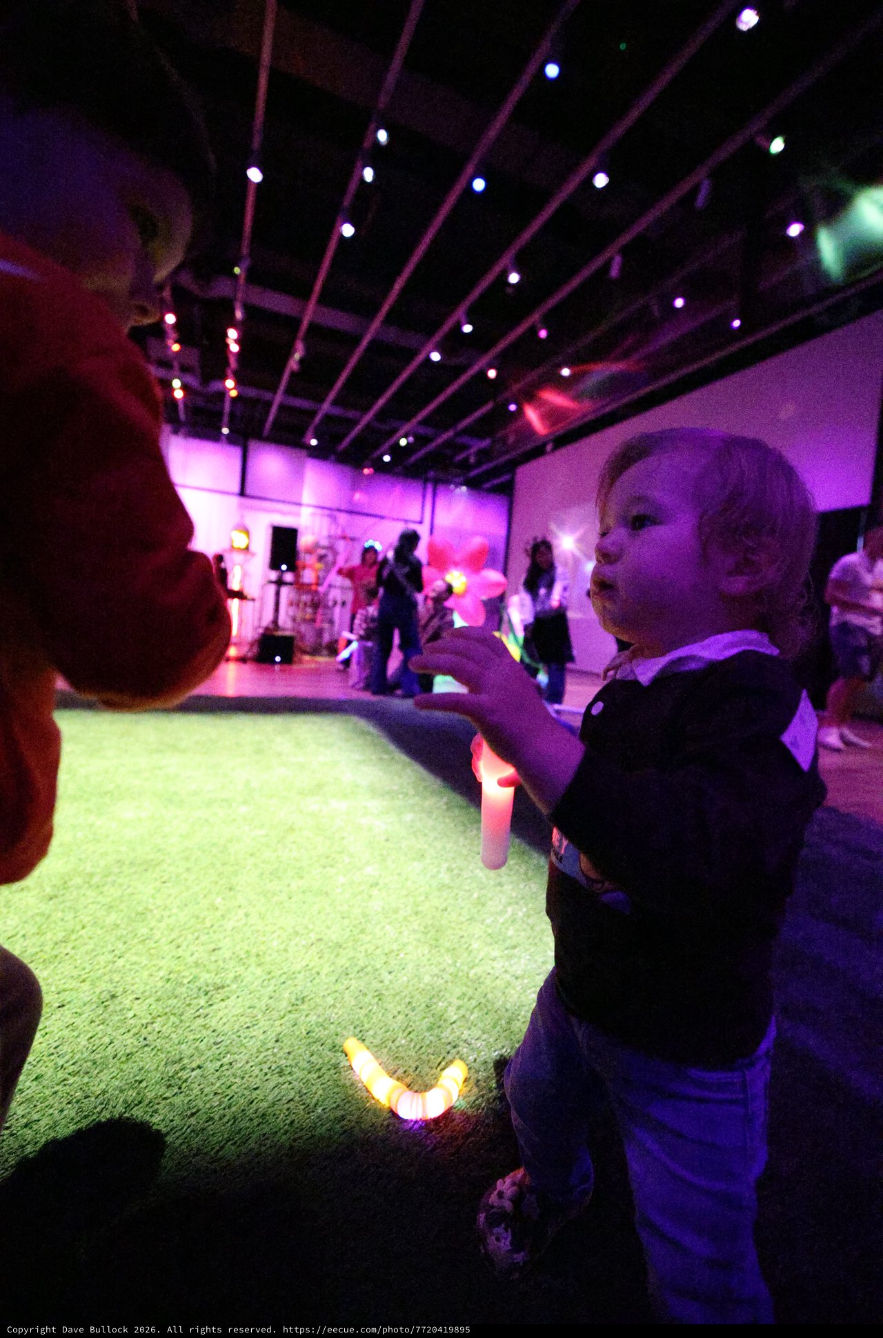 Child Dancing with Glow Stick at Baby Rave Event