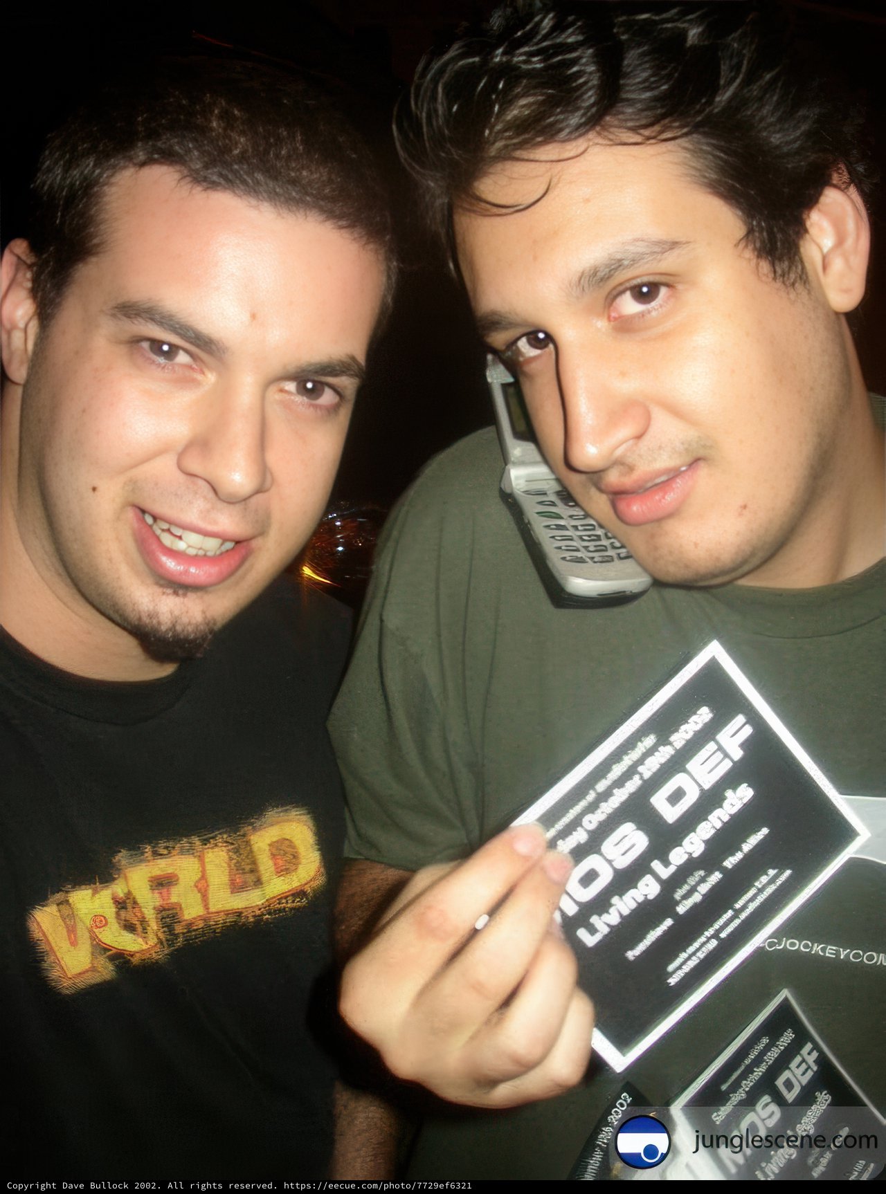 Two men holding up a card with an advertisement