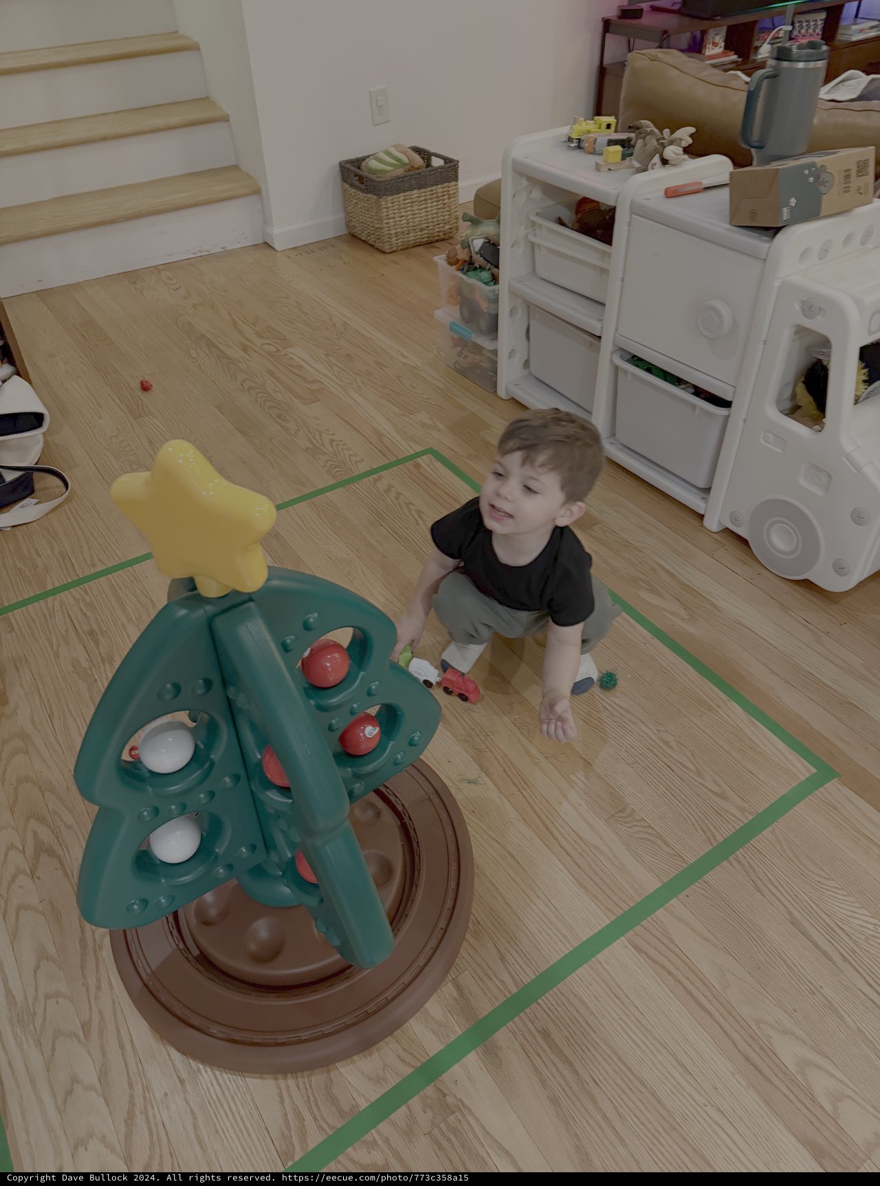 Child Playing with Tree-Shaped Activity Toy