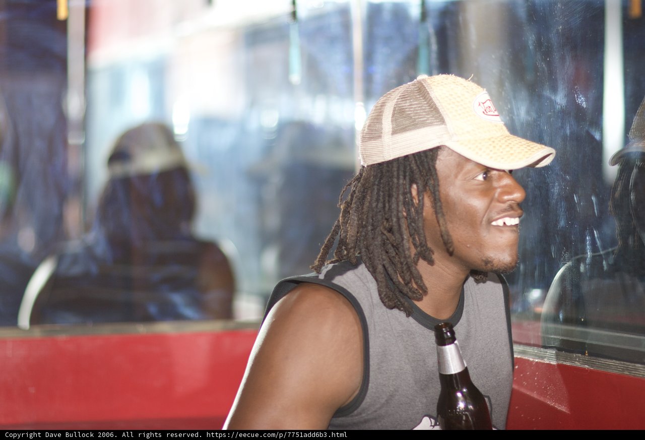 Dreadlocked Man Enjoying a Beer at a Table