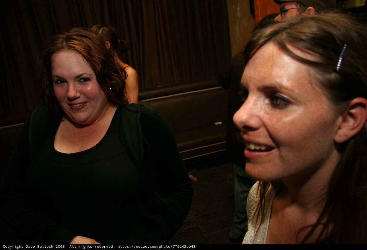 Two Women Laughing Together at a Dark Bar