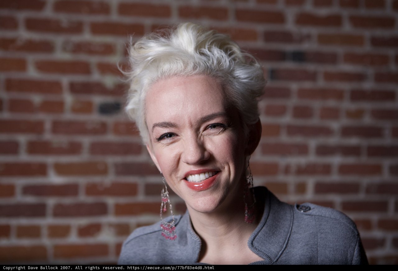Joyful Woman in front of Brick Wall