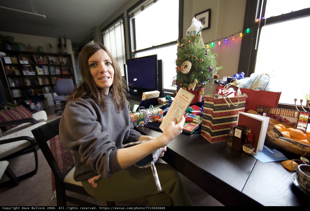Woman Unwrapping Christmas Gifts at Holiday Table