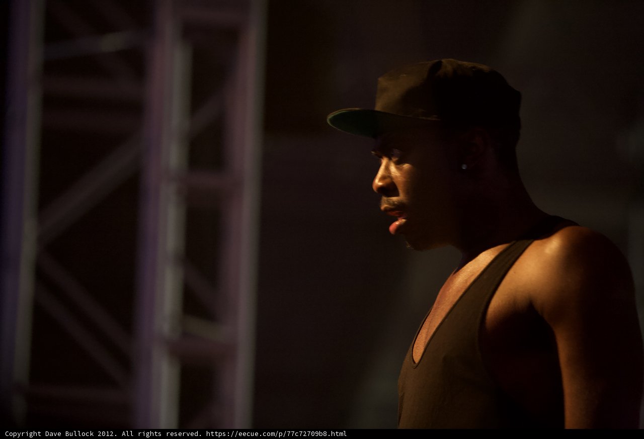 Man in Black Tank Top and Hat Takes the Stage