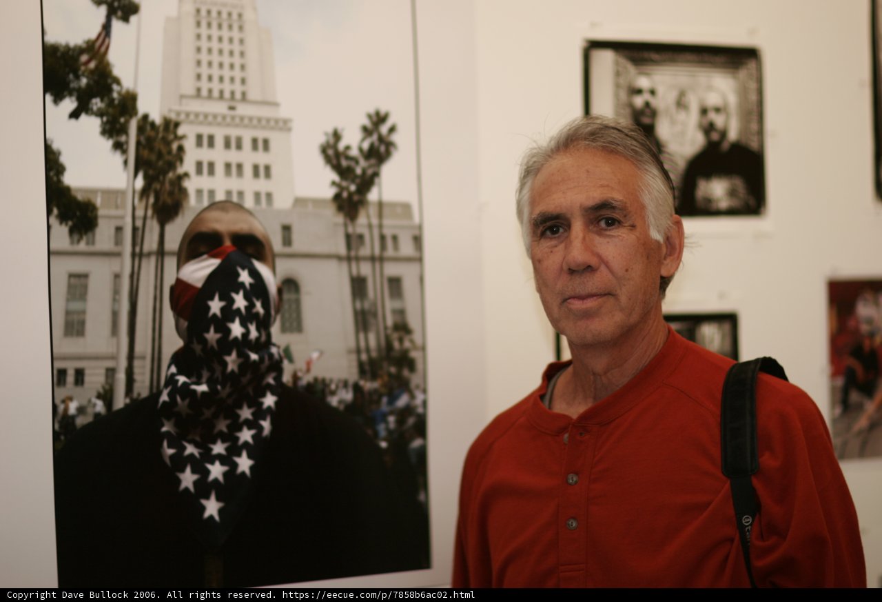 Man in Red Shirt Stands by Framed Building Photo