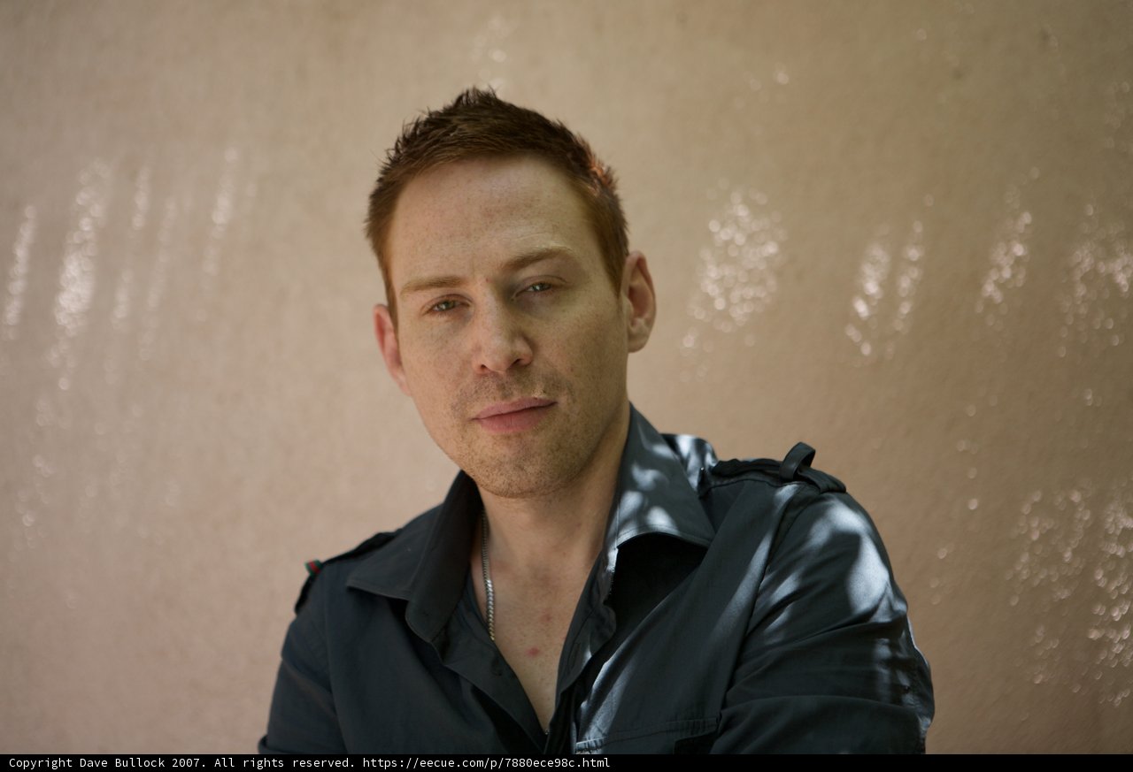 Blue-shirted man stares into the camera