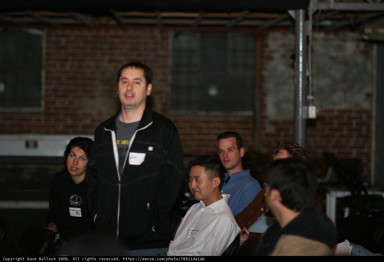 Tim Chen addressing the crowd in his cozy hoodie