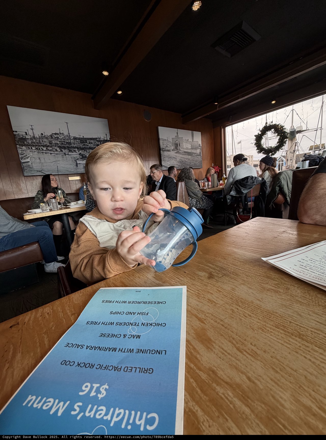 Young Child with Sippy Cup at Restaurant Table
