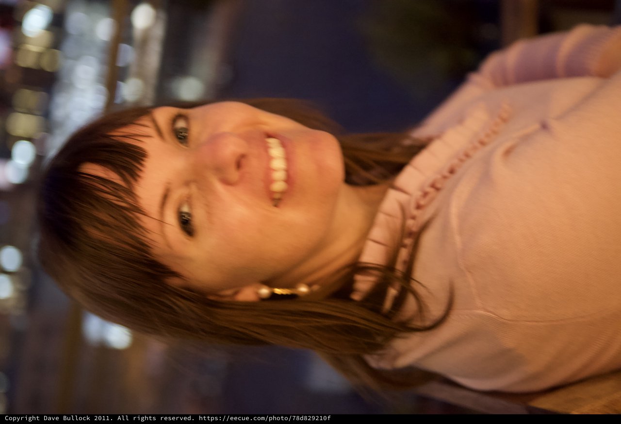 Smiling Woman at Night with City Lights Behind